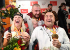 Foto: Paralimpiādes medaļnieki Apinis, Dadzīte un Bergs atgriežas Latvijā