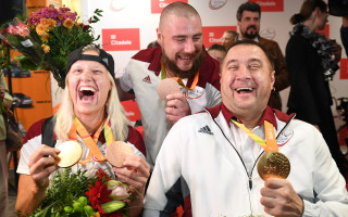 Foto: Paralimpiādes medaļnieki Apinis, Dadzīte un Bergs atgriežas Latvijā