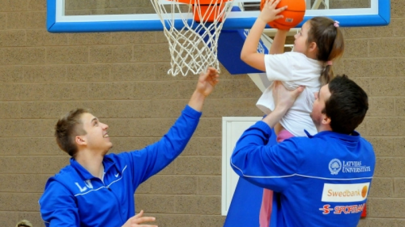 Latvijas Universitātes basketbolisti palīdz mazajai aizkrauklietei iepazīt basketbola skaistumu.
Foto: Romualds Vambuts
