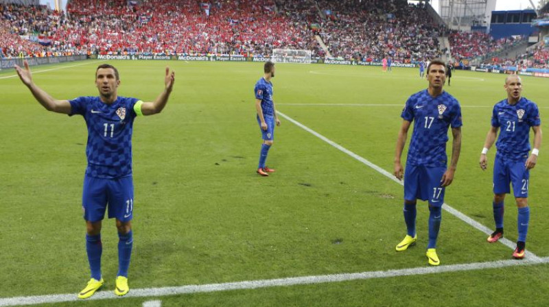 Horvātijas izlases futbolisti vēršas pie saviem līdzjutējiem, cenšoties viņus nomierināt
Foto: AP/Scanpix