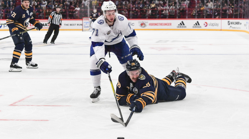 Zemgus Girgensons (uz ledus) cīņā par ripu. Foto: AFP/Scanpix