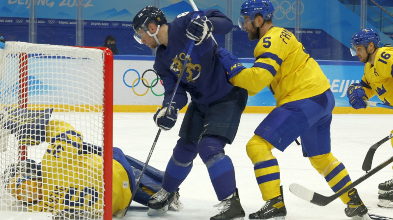 Somijas izlases uzbrucējs Īro Pakarinens iestumj ripu Zviedrijas vārtos. Foto: Jonathan Ernst/Reuters/Scanpix