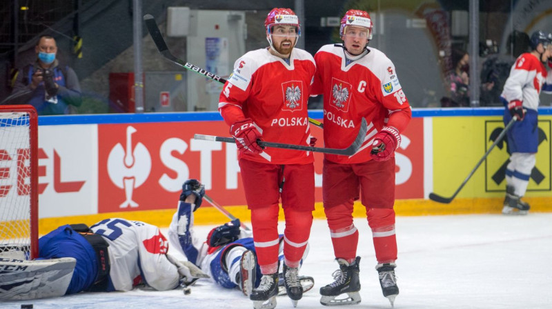 Polijas izlases hokejisti Filips Komorskis (Nr. 5) un Kamils Dzjubinskis (Nr. 19) pēc vārtu guvuma. Foto: IIHF