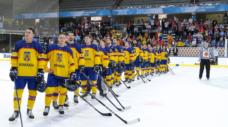 Rumānijas hokejisti valsts himnas atskaņošanas laikā pēc uzvaras pār Ungāriju. Foto: IIHF