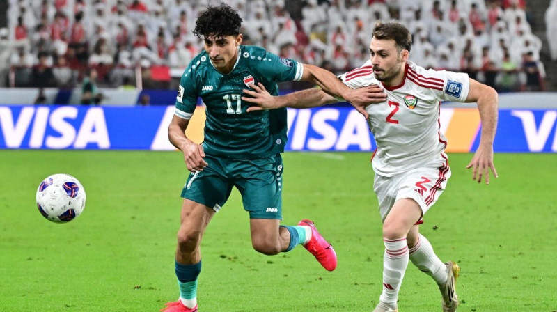 Irākietis Ali Džasims (Nr. 17) cīņā par bumbu pret Apvienoto Arābu Emirātu portugāli Rubenu Amaralu (Nr. 2). Foto: AFC