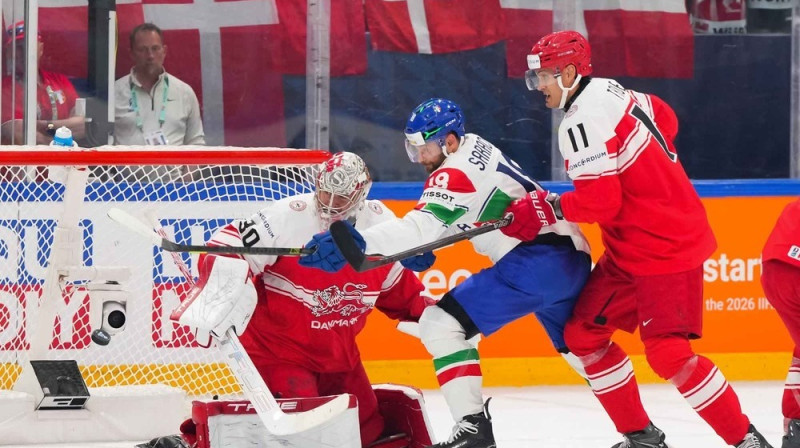 Itālijas izlases uzbrucējs Nikolass Sarasino mēģina pārspēt Madsu Sogārdu. Foto: Matt Zambonin/IIHF