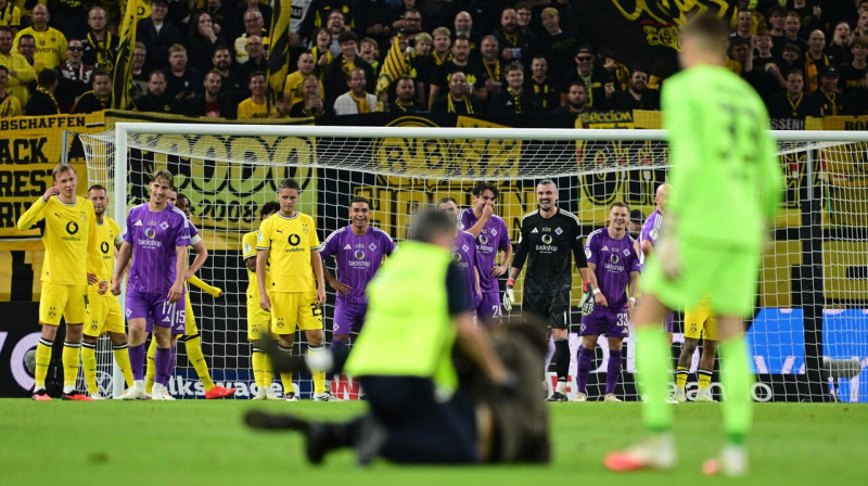 "Hamburg-Eimsbütteler Ballspiel-Club" (HEBC) un Dortmundes "Borussia" futbolisti uzjautrinās par laukumā izskrējušo "strīkeri". 
Foto: Tim Groothuis/Witters/Scanpix